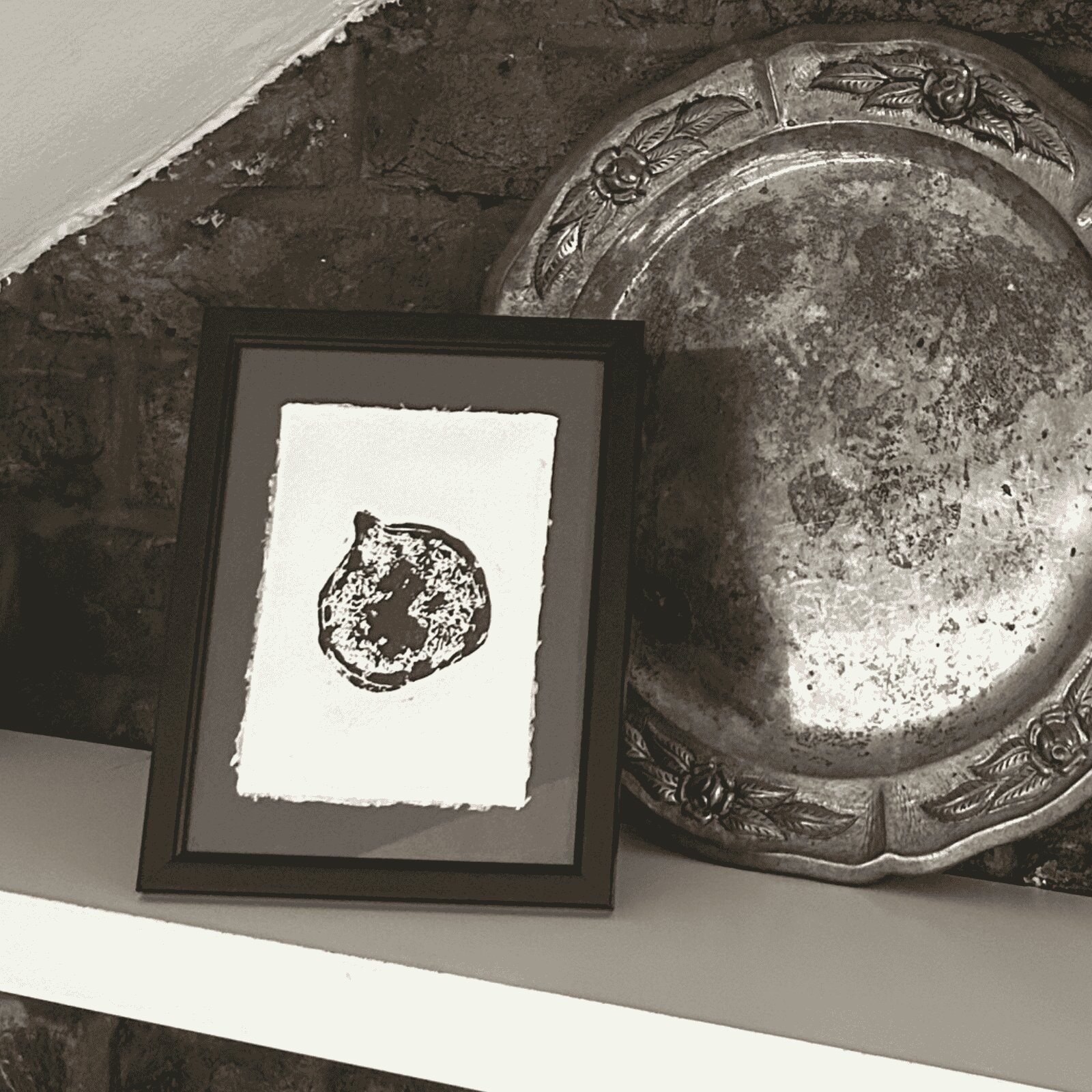 Framed figgy artwork on shelf